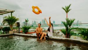 a man and a woman sitting in a swimming pool at Viajero Casco Viejo Hostel in Panama City