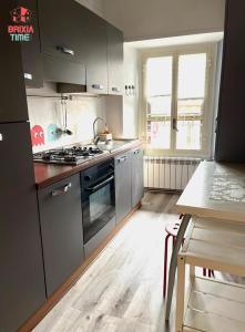 Una cocina con electrodomésticos de acero inoxidable y una mesa. en Brixia Time Case - Indipendenza, en Brescia