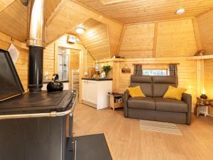 a living room with a couch and a stove at Chalet Hazel Bothy by Interhome in Coldstone