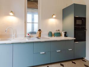 a kitchen with blue cabinets and a sink at Holiday Home Maison Amour by Interhome in Dives-sur-Mer