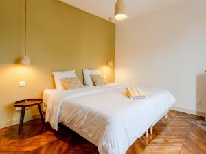 a bedroom with a large white bed and a table at Holiday Home Maison Amour by Interhome in Dives-sur-Mer
