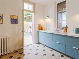 a kitchen with blue and white cabinets and a patio at Holiday Home Maison Amour by Interhome in Dives-sur-Mer