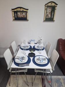 a dining room table with white chairs and blue and white plates at Hafnargata 44 Keflavík 230 in Keflavík