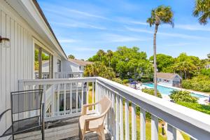 einen Balkon mit einem Stuhl und einem Pool in der Unterkunft Lagoon Villa 6 - 5 Min Walk to Beach! Top Floor! in Isle of Palms