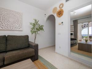 a living room with a couch and a mirror at Apartment Imperial Park-23 by Interhome in Casas de Torrat +21 photos