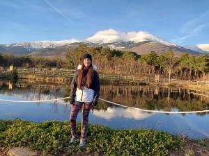 a woman holding a rope in front of a lake at Casa Rural La Milagrosa in San Martín de Moncayo