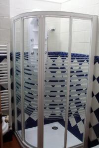 y baño con ducha y azulejos azules y blancos. en Apartamentos Flordelinto, en La Cárcoba 19 fotos más