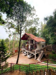 una casa con coches aparcados delante de ella en Edakkal Village Resort - A Premium Boutique Lodging, Wayanad, en Ambalavayal