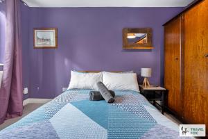 a bedroom with purple walls and a bed at Emma's Central House & Parking in Nottingham