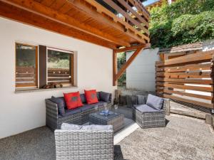 a patio with a couch and two chairs and a table at Apartment Rochemont B26 by Interhome in Icogne
