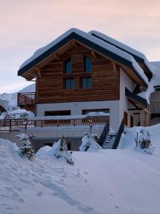 a house with snow on the ground in front of it at Germain Ski Lodge in La Toussuire