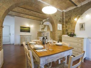 Un comedor con mesa y sillas de madera. en Apartment Torrenieri by Interhome, en Vergelle