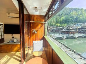 a balcony of a boat with a view of a river at Fenghuang Color River View Villa in Fenghuang