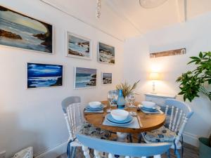 a dining room with a wooden table and chairs at Holiday Home Mermaid Cottage by Interhome in Mevagissey