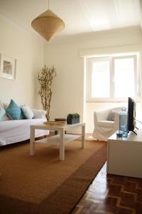 ein Wohnzimmer mit einem Sofa und einem Couchtisch in der Unterkunft Apartment House in Costa da Caparica