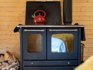 a blue stove with a red tea kettle on top at Apartment Ghillie's Bothy by Interhome in Coldstone +14 photos