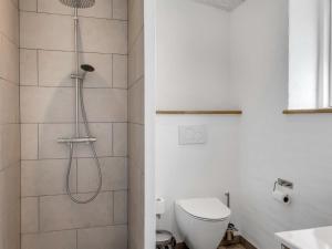 a white bathroom with a shower and a toilet at Holiday Home Wolter - 1-7km from the sea by Interhome in Vesterø Havn +22 photos