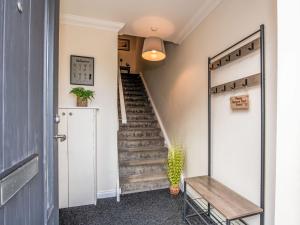 a hallway with stairs and a door with a mirror at Apartment Varis Haven by Interhome in Forres