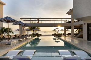 a pool with chairs and umbrellas at a resort at Negril Footeprints Hotel in Negril