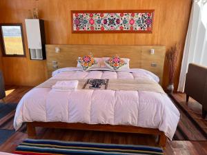 une chambre avec un grand lit avec une tête de lit en bois dans l'établissement QHOCHA Titikaka lodge, à Puno 9 autres photos