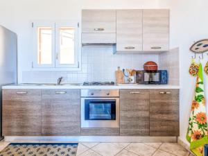a kitchen with wooden cabinets and a stove top oven at Apartment Vista Paradiso by Interhome in Cascabraga +21 photos