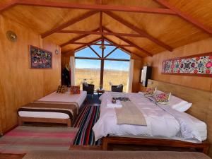 une chambre avec deux lits et une fenêtre dans l'établissement QHOCHA Titikaka lodge, à Puno