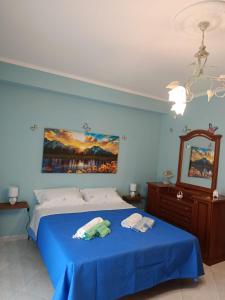 a bedroom with a blue bed and a mirror at Etna Rose House in Piedimonte Etneo +7 photos