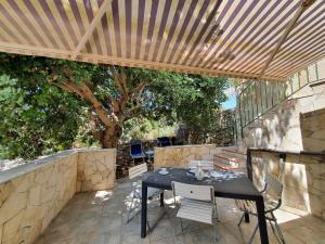 un patio con mesa y sillas bajo una pérgola de madera en Holiday Home Casa Paolina by Interhome, en Módica