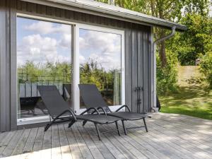 two lounge chairs sitting on a deck near a window at Holiday Home Utsikten by Interhome in Grimsholmen +18 photos