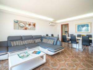 ein Wohnzimmer mit einem blauen Sofa und einem Tisch in der Unterkunft Holiday Home Villa Can Rosito by Interhome in S'Illot