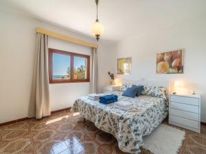 ein Schlafzimmer mit einem Bett mit blauen Kissen und einem Fenster in der Unterkunft Holiday Home Villa Can Rosito by Interhome in S'Illot + 19 Fotos