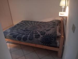 een klein bed in een kleine kamer met een sprei bij Villa Voltina in Livorno