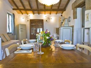 un comedor con una mesa de madera con platos y vasos en Apartment Asciano by Interhome, en Vergelle