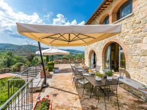 a patio with tables and chairs under an umbrella at Holiday Home Casa Padronale by Interhome in Corti