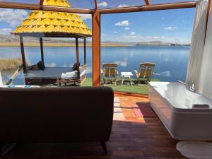 un salon avec baignoire et vue sur l'eau dans l'établissement QHOCHA Titikaka lodge, à Puno