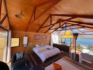 une chambre avec un lit et une vue sur l'océan dans l'établissement QHOCHA Titikaka lodge, à Puno