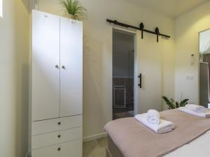 a bedroom with two beds and a large white cabinet at Apartment Appartement 'Bed by Al' by Interhome in Kortgene