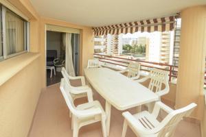 ein weißer Tisch und Stühle auf einem Balkon in der Unterkunft Apartamentos Marblau Varios 1, 2 y 3 dormitorios - Julio y Agosto SOLO FAMILIAS in Playa de Gandia