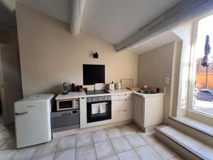 a small kitchen with a stove and a sink at Les canisses in Eygalières