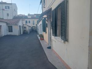 an empty alley with green shutters on a building at Villa Voltina in Livorno
