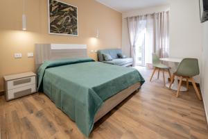 a bedroom with a bed and a table and a couch at Casa vacanze Gheos in Milazzo