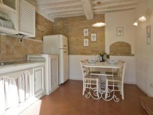 Una cocina con una mesa con sillas y un refrigerador. en Apartment Monteroni by Interhome, en Vergelle