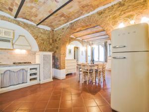 Una cocina con refrigerador y una mesa con sillas. en Apartment Monteroni by Interhome, en Vergelle