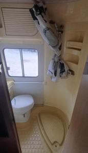 ティラナにあるrent camperのトイレと窓のある小さなバスルーム