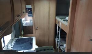 ティラナにあるrent camperの小さな客室で、二段ベッドとシンクが備わります。