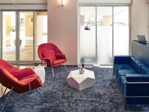 a living room with two chairs and a couch at Mercure Sao Paulo Vila Olimpia in São Paulo +188 photos