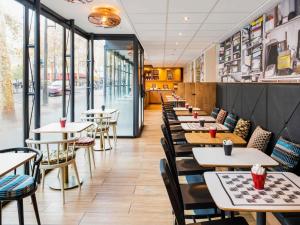 une rangée de tables et de chaises dans un restaurant dans l'établissement ibis Paris Gare de Lyon Diderot, à Paris