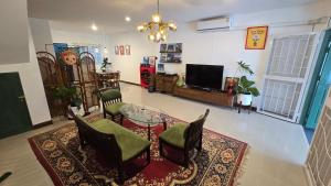 a living room with a table and chairs and a television at คาเมะโฮม บางแสน in Ban Bang Saen (1) +26 photos