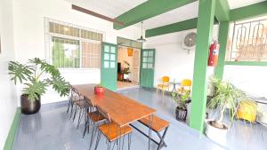 a dining room with a wooden table and chairs at คาเมะโฮม บางแสน in Ban Bang Saen (1)