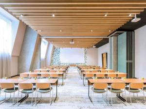 une rangée de tables et de chaises dans une pièce dans l'établissement Novotel Sevilla, à Séville 216 autres photos